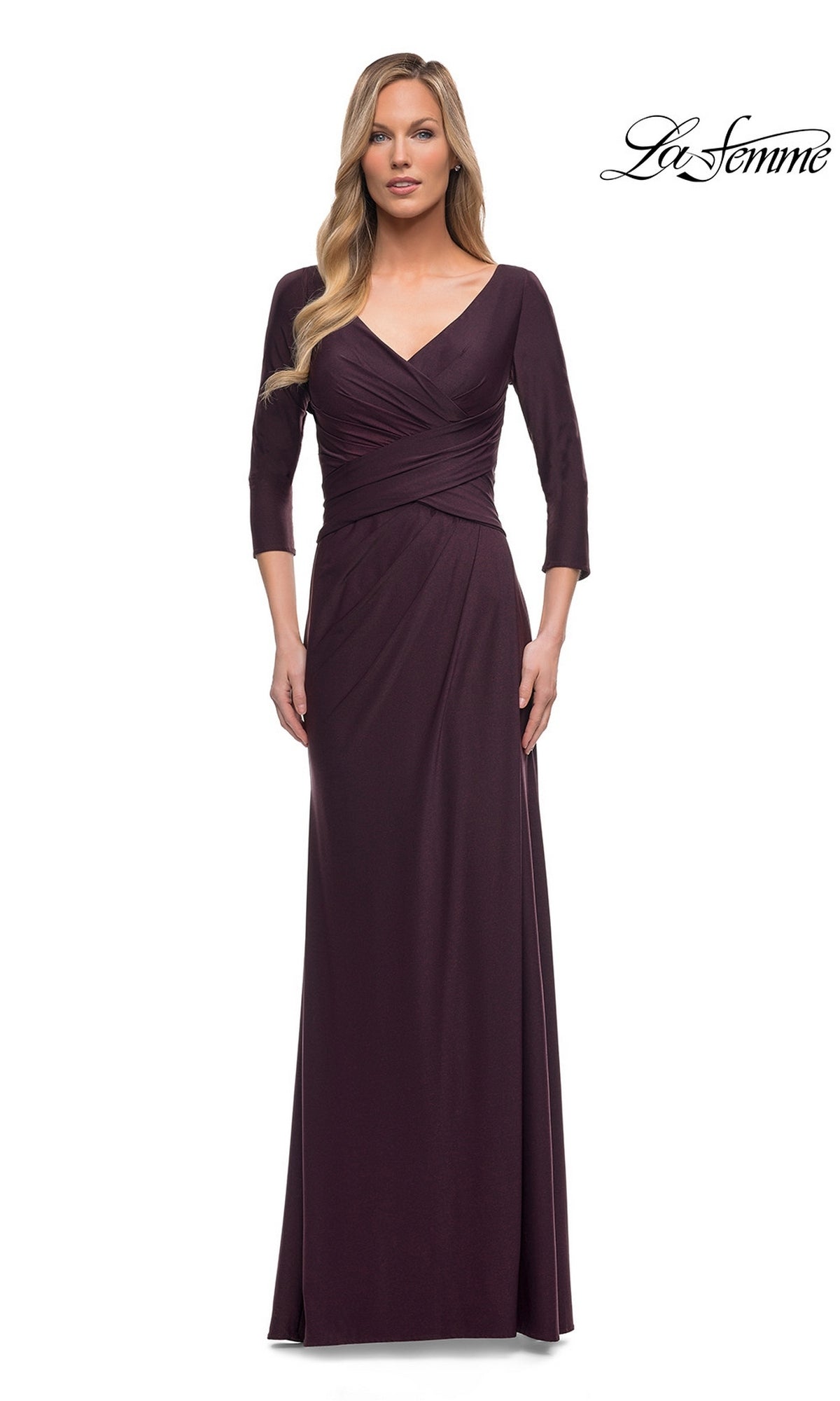 Woman in a dark garnet Long Formal Dress: La Femme 29223 with sheath silhouette, V-neckline, and three-quarter sleeves, standing by the โLa Femmeโ logo.